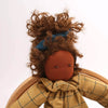 Textile doll with plaid coat and green pants on a white background