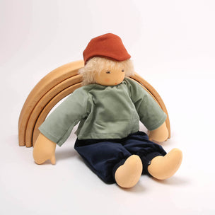 Toy figure wearing a green shirt and red cap sitting behind wooden rings on a white background