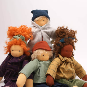 Four dolls with different hairstyles and clothing on a white background