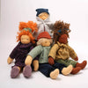 Four dolls with different hairstyles and clothing on a white background