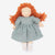 A handmade cloth doll with curly orange-red hair, a dusty blue dress, and white socks, photographed against a clean white background.