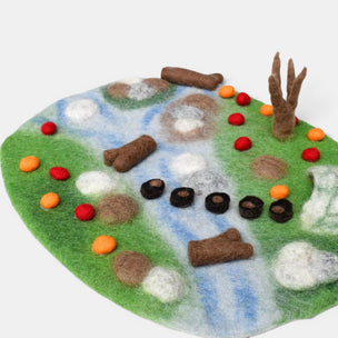 Felt play mat with natural landscape design on a white background