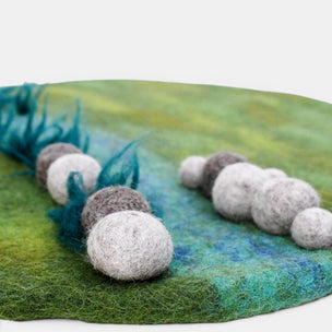 Felted balls on a textured green surface