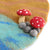 A close-up of a felted wool craft piece featuring two red mushrooms with white spots, beige stems, and gray felted wool bases, attached to a larger brown and teal felted wool background.