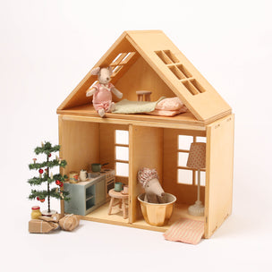 Wooden dollhouse with interior furniture and decorative items on a white background