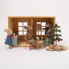 Miniature toy set with mice in a living room scene, including a Christmas tree and presents.