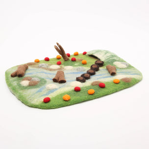 Felted play mat with animal figures on a white background