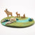 Wooden animal toys on a felted landscape with a swan, deer, and other elements.