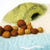 Felted toy with a green top and brown felt balls on a white background