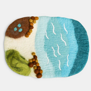 Felted artwork with a landscape design featuring water, land, and trees on a white background.