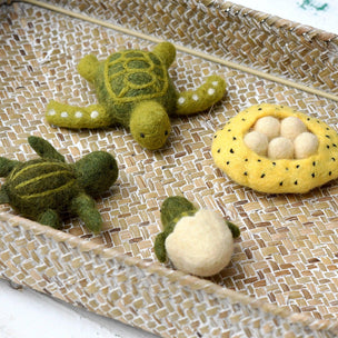Set of felted turtle toys on a woven surface