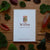 Card with 'Willow' design on a wooden surface with leaves