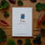 Card with yew plant illustration and text on a wooden surface with leaves