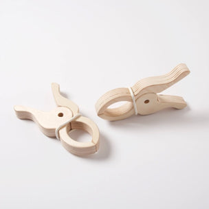 Two large wooden play clips with a white rubber band